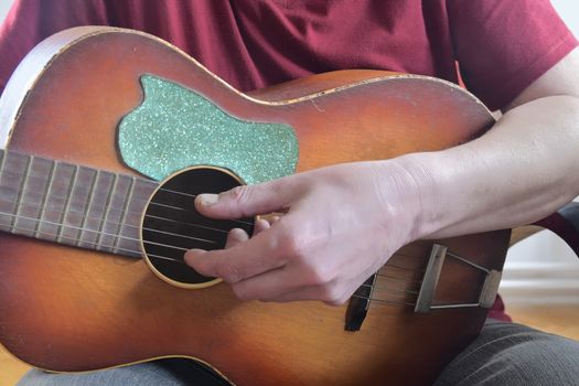 The hand of man playing guitar. Closeup. Musical concept.