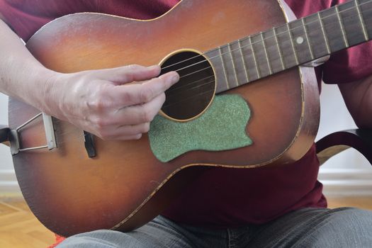 Male hand playing on acoustic guitar. Close-up. Musical concept.