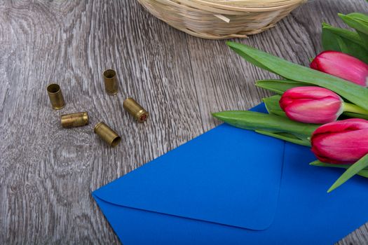 Pink envelope with tulips on a wooden table