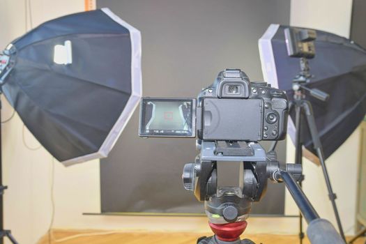 Empty photo studio with lighting equipment. Professional camera with picture of photo studio. 