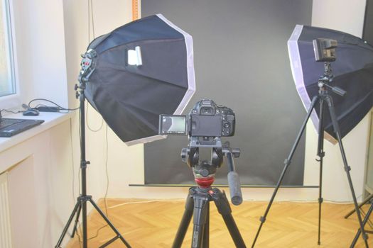 Empty photo studio with lighting equipment. Professional camera with picture of photo studio. 