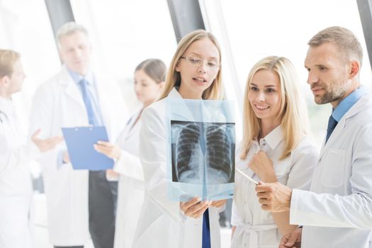 Group of young doctors look and discuss x-ray in a clinic or hospital