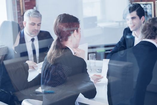 Business colleagues meeting in conference room, shot through glass