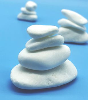 spa relax concept white stones isolated on blue background perspective