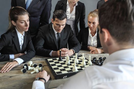 Business people playing chess, team of workers losing, leader is winning