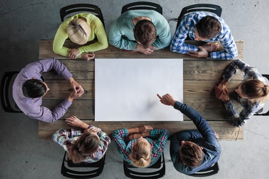 Hipster business teamwork brainstorming planning meeting concept, people sitting around the table with white paper