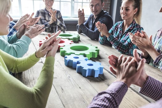 Business people with colorful cogs of business clap hands, problem sloution concept