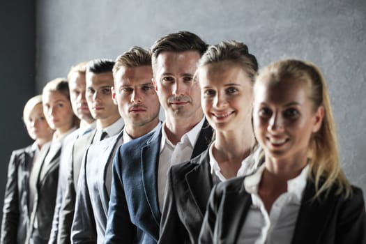 Serious business team standing in a row at office