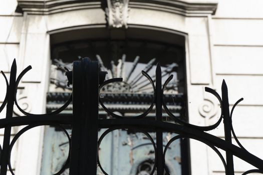 looks from the outside behind iron gate ancient and carved in Gothic style