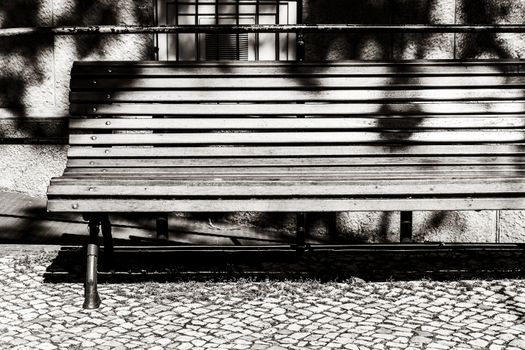 A wooden bench in the sun black and white photos