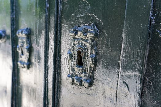 Antique key lock on green door in lisbon