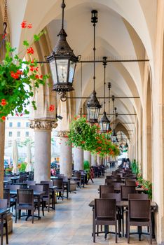 beautiful street cafe, located in the arch of shopping arcades in the center of Krakow in the square