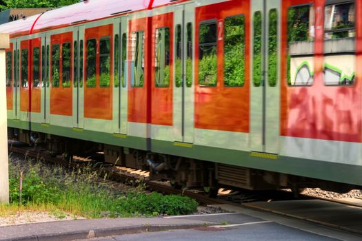 S-Bahn train passes a restricted railway crossing.