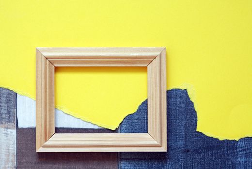 Blank wooden picture frame on abstract color background