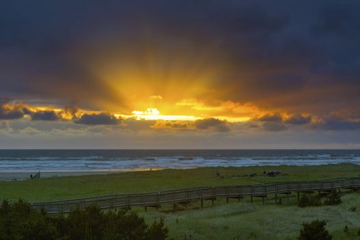 Sun rays beams in the sky over boardwalk in Long Beach Washington State during sunset