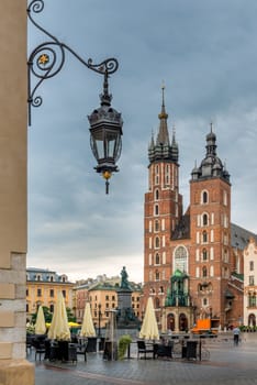 Beautiful retro lantern in the foreground with a view of the main square of Kraków, Poland