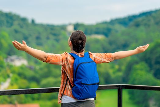 woman tourist with arms outstretched enjoys freedom in nature