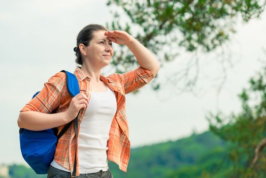 young woman with a backpack on a weekend trip looking into the distance