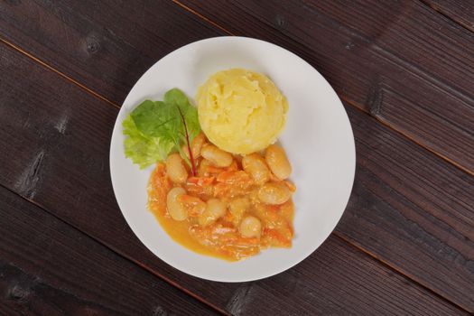 Beans with carrots and potatoes on a wooden table