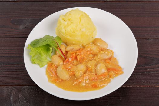 Beans with carrots and potatoes on a wooden table