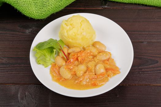 Beans with carrots and potatoes on a wooden table