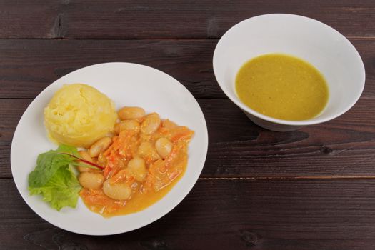 Beans with carrots and potatoes on a wooden table