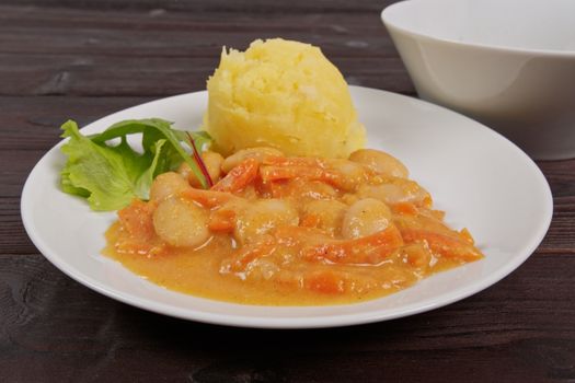 Beans with carrots and potatoes on a wooden table