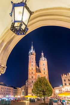 arch with lamp, night photo of the Mariak Church in the center of Krakow, Poland