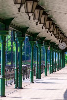 empty station platform in retro style with round clock