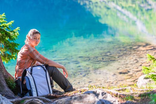 portrait of a woman on a hike resting near a lake in the Tatra mountains