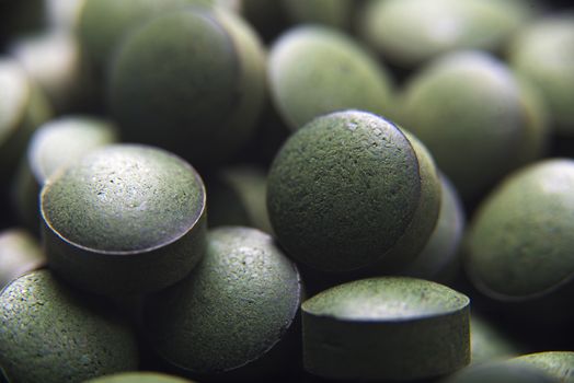 Close up of many spirulina tablets with low depth of field. Horizontal image.