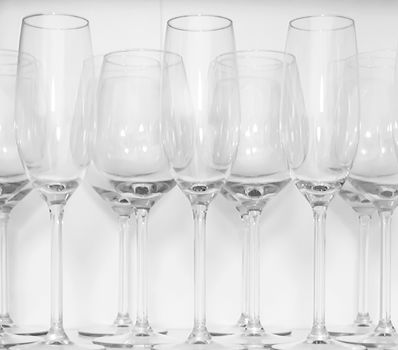 Wine glasses standing in rows on a white shelf