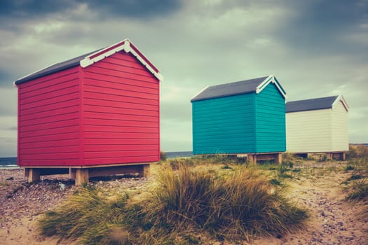 Retro Filtered Colored Vintage Beach Huts On A Cold British Beach