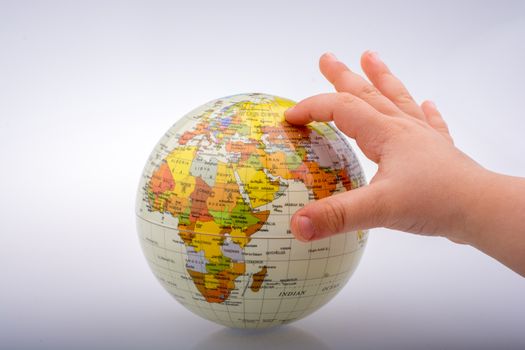 Child holding a globe in on a white background