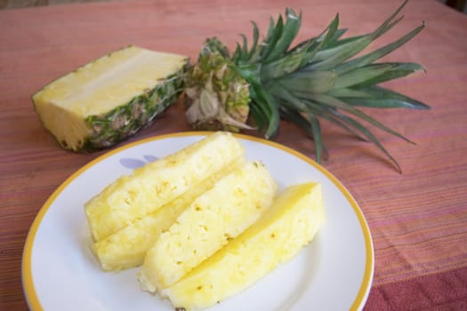 heap of fresh sliced pineapples in a white dish