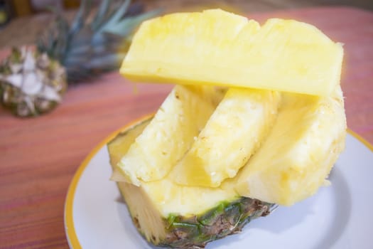 heap of fresh sliced pineapples in a white dish