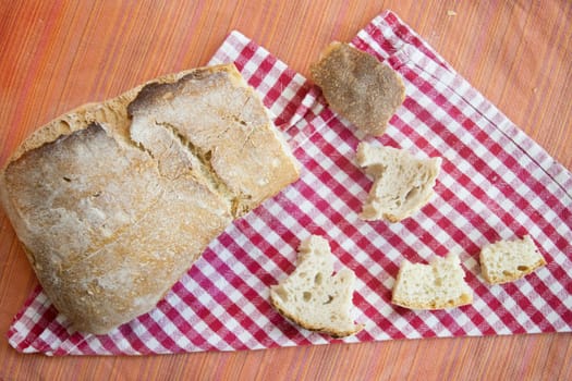 loaf of french bread with near some small pieces of it