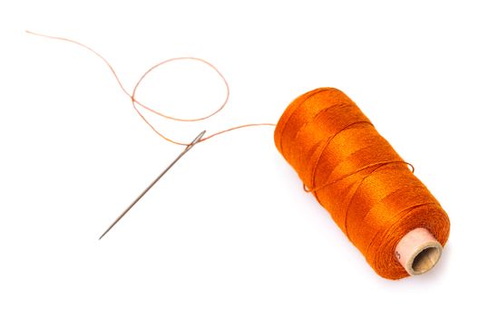 spool of thread with a needle on white isolated background