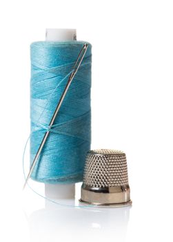 Thread with needle and thimble on white isolated background