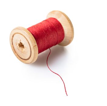 spool of red thread on white isolated background