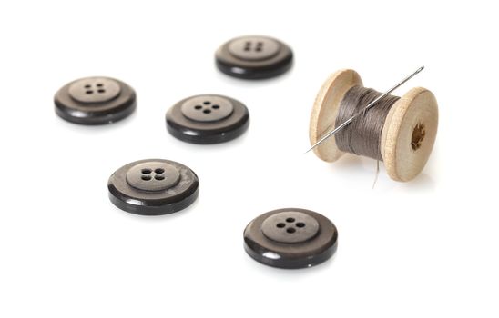 spool of thread and buttons on white isolated background