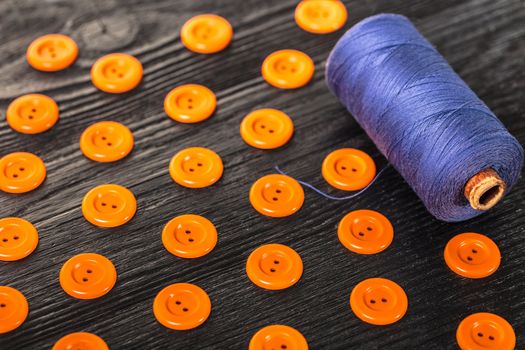 spool of threads and buttons on a wooden background
