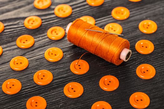 spool of threads and buttons on a wooden background