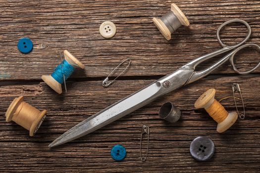 scissors and sewing accessories on a wooden background