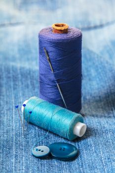 blue threads with buttons on the background of denim