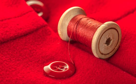 red thread with buttons on woolen fabric background