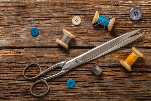 scissors and sewing accessories on a wooden background