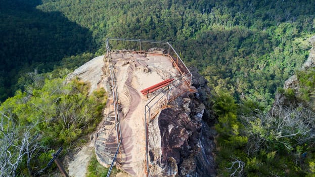 Overhead views to a small rocky outcrop and fenced lookout into the valley below.  Blue Mountains Australia