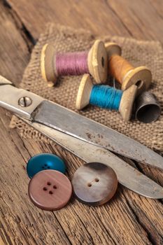 scissors and sewing accessories on a wooden background