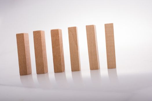 Wooden Domino Blocks in a line on a white background